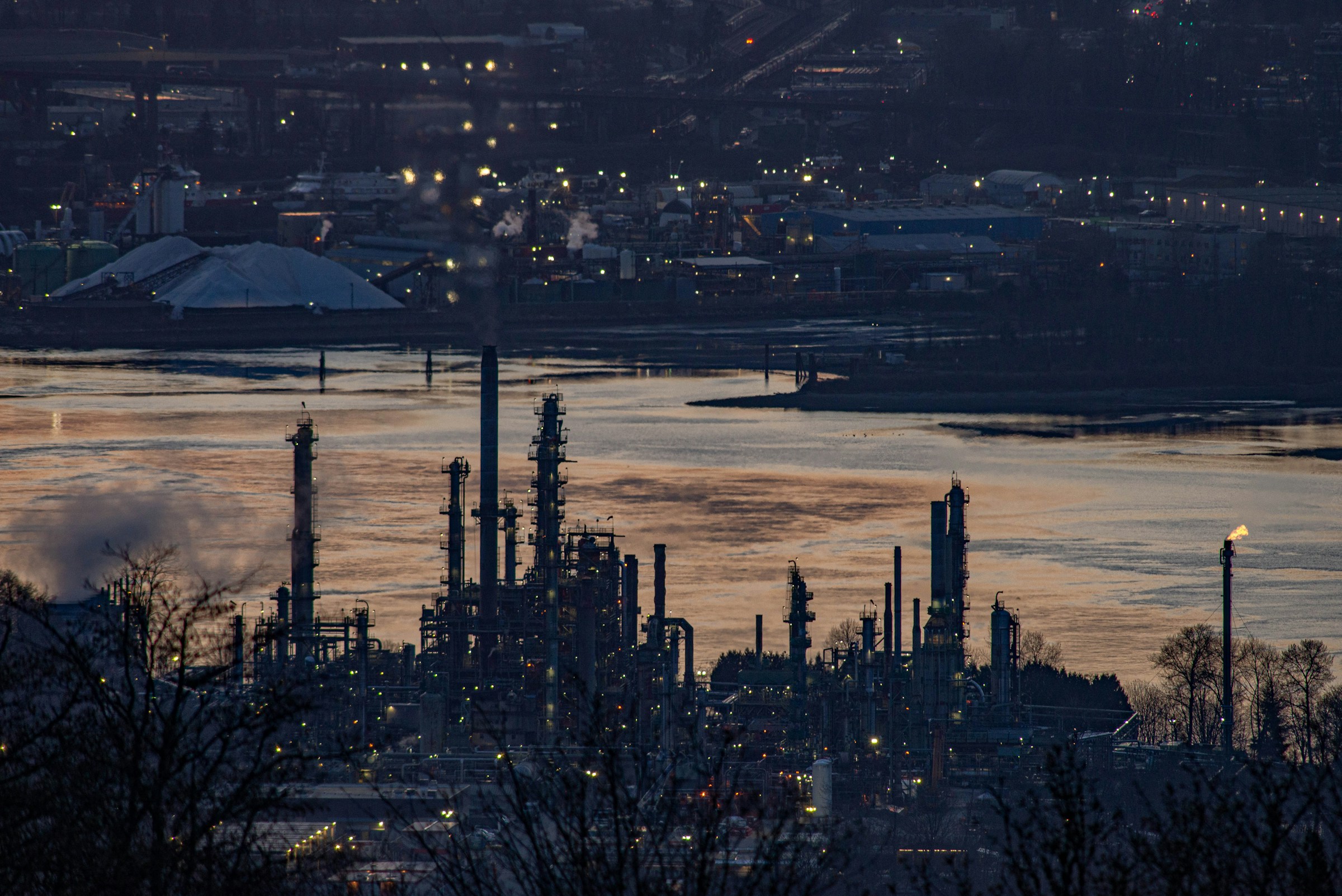 Oil refinery beside the water at dusk